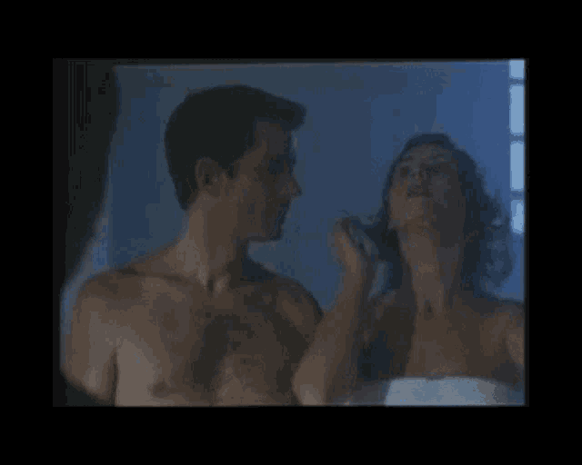 a man and a woman are looking at each other in a bathroom