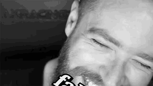 a man with a beard has a sticker on his face that says f.
