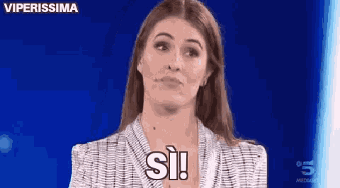 a woman is talking into a microphone and saying si