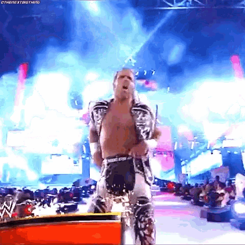 a man in a wrestling outfit is standing on a stage in front of a crowd with the hashtag #thenextbigthing