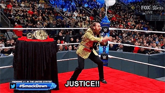 a man in a gold suit is standing in a wrestling ring and saying justice