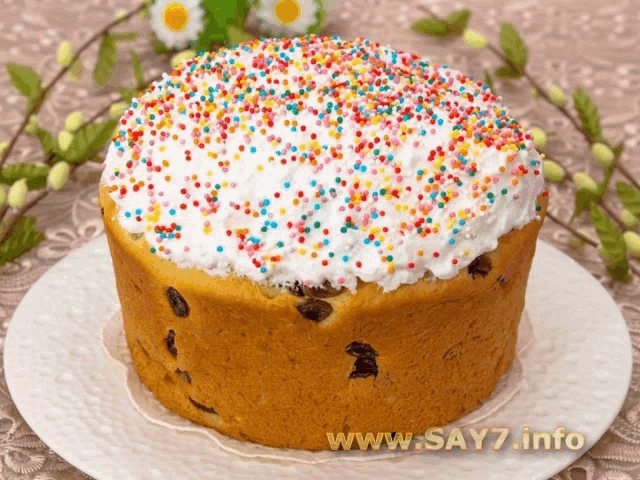 a cake with white frosting and sprinkles is on a white plate