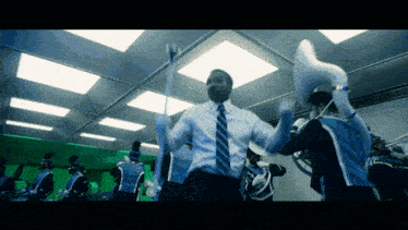 a man in a suit and tie is dancing in front of a band