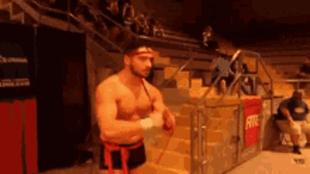 a man without a shirt is standing in front of a staircase with a sign that says fire