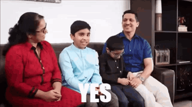 a family is sitting on a couch with the word yes written in white