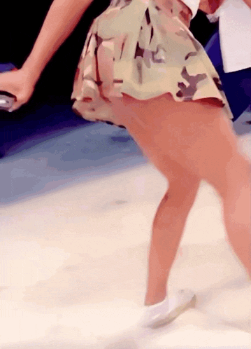 a woman in a camouflage skirt is walking
