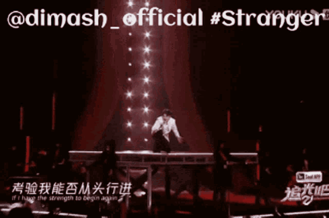a man singing into a microphone on a stage with the words " @dimash_official #stranger " on the bottom