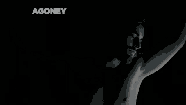 a shirtless man is standing in the dark with his arms outstretched and the word agoney above him .