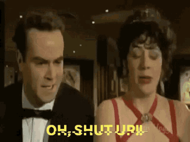 a man in a tuxedo and bow tie is standing next to a woman in a red dress who is saying oh shut up