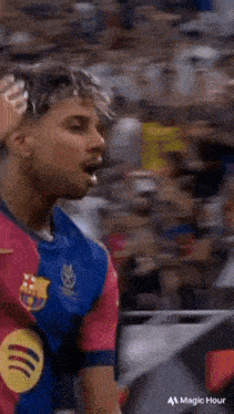 a man in a barcelona jersey stands in a crowd