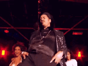 a man and a woman are dancing on a stage with red lights