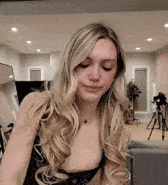 a woman with long blonde hair is wearing a black lace bra