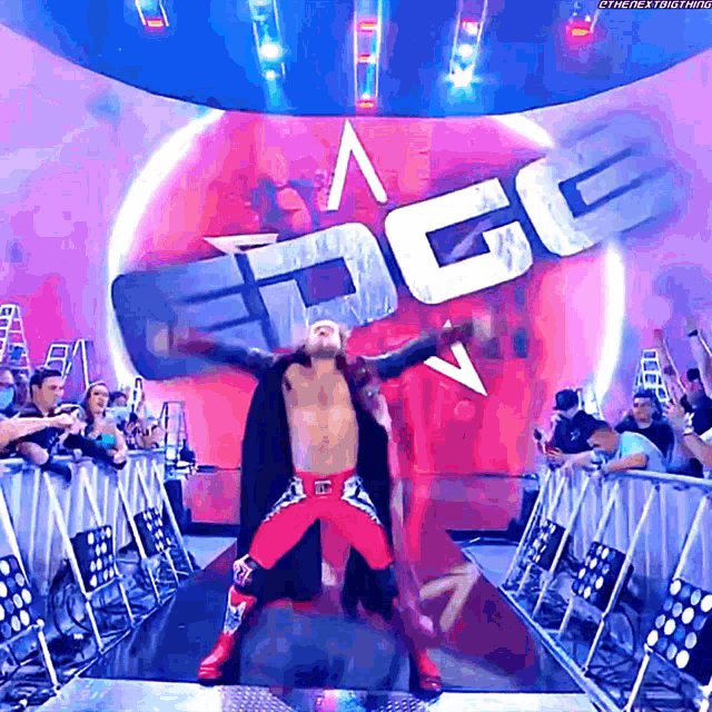 a wrestler stands in front of a sign that says " edge "