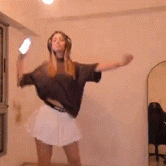 a woman wearing headphones and a black shirt is dancing