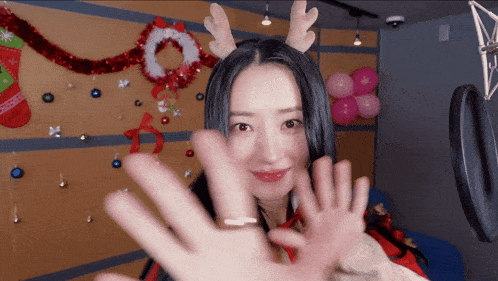 a woman wearing reindeer antlers and a christmas stocking