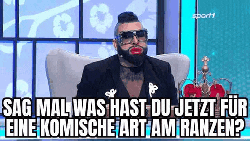 a man with a beard is sitting in a chair wearing sunglasses and red lipstick .