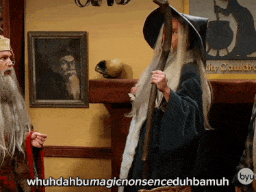 a man in a wizard costume says " whuhdahbumagicnonsenceduhbamuh " in front of a fireplace