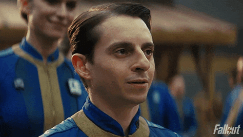a man in a fallout uniform is smiling and looking at the camera