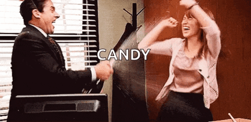 a man and a woman are dancing in an office with the word candy in the background .