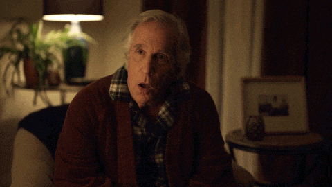 a man sitting on a couch says holy sh t