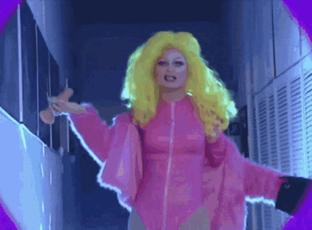 a woman with bright yellow hair is wearing a pink jacket