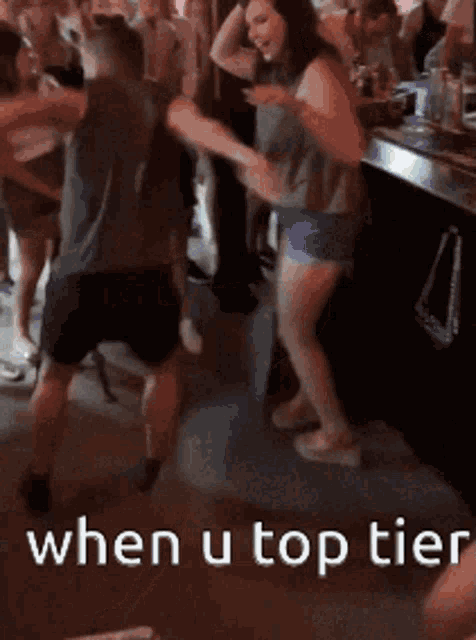 a group of people are dancing in a room with the words when u top tier on the bottom