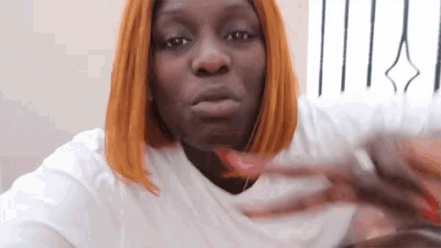 a woman with red hair is making a funny face while holding a bottle of wine .