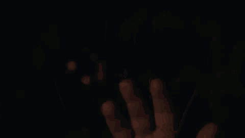a close up of a person 's hand against a black background .