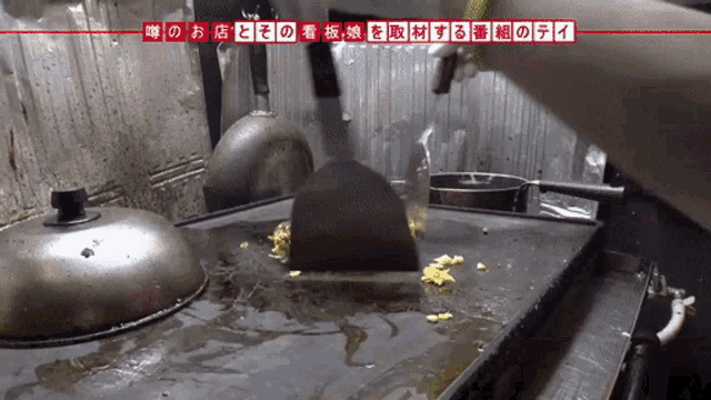 a person is cooking on a dirty stove top with foreign writing on the bottom