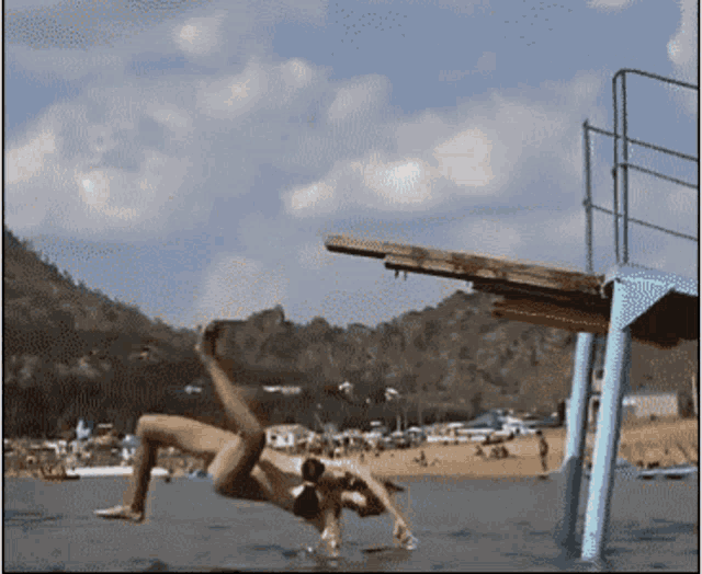 a man in a bikini is doing a handstand in the water
