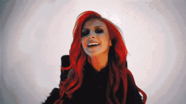a woman with red hair is smiling and wearing black