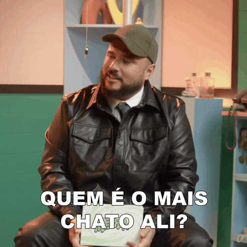 a man in a leather jacket is holding a book that says chato ali
