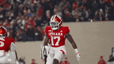 a football player wearing a red indiana jersey is running on the field