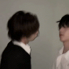 a man and a woman are standing next to each other and looking at each other .