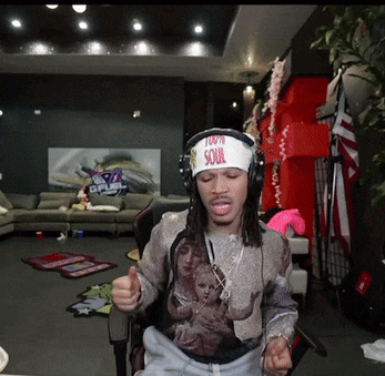 a man wearing headphones and a headband that says 100 % soul is giving a thumbs up