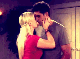 a man and a woman are kissing in a room in front of a door .