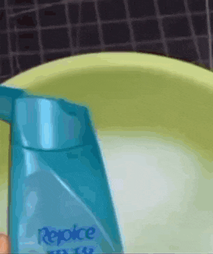 a bottle of rejoice shampoo is being poured into a bowl