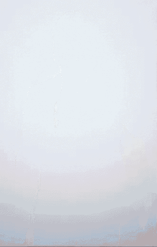 a blurry picture of a person walking in front of a white background