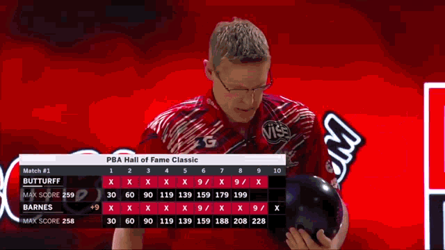 a man is holding a bowling ball in front of a scoreboard for the pba hall of fame classic