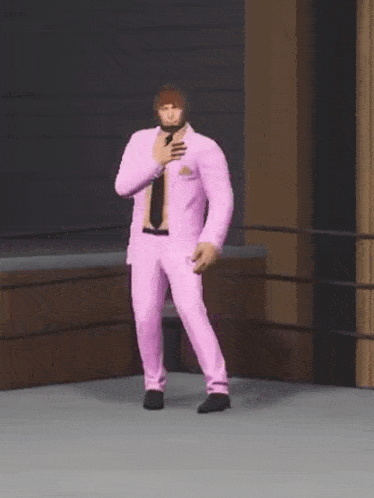 a man in a pink suit and tie is standing in a wrestling ring