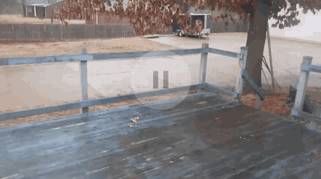 a wooden deck with a blue fence and a pause button