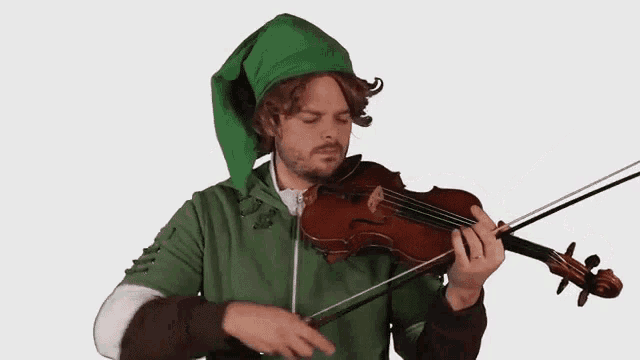 a man in a green elf hat plays a violin