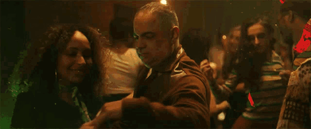 a group of people are dancing in a dark room with smoke coming out of their hair .