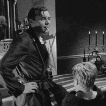 a man in a robe is smoking a cigarette while standing next to another man