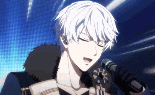 a man with white hair is singing into a microphone while standing on a stage .