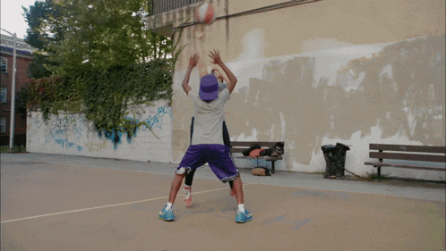 a woman in a blue tank top is playing basketball in a hoop