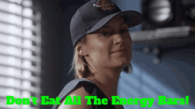 a woman wearing a baseball cap with the words " do n't eat all the energy bars " on the bottom