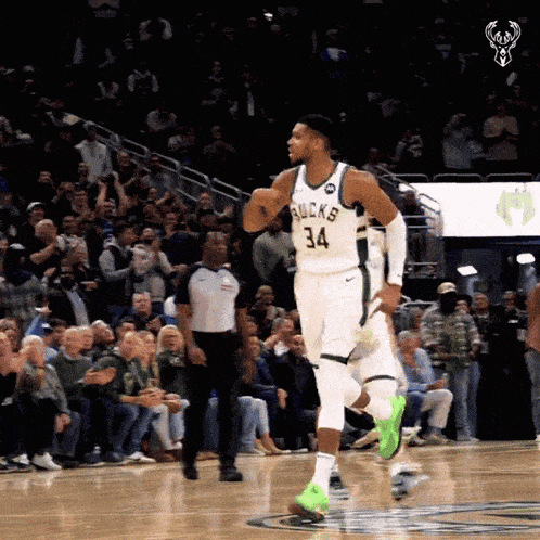 a basketball player with the number 34 on his jersey runs on the court
