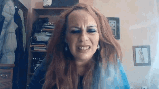 a woman with red hair is making a funny face with her mouth open