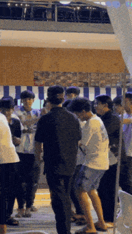a group of young men are standing in a line in a room .